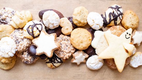 Wein und Käse, angerichtet mit roten und hellen Trauben und herbstlichen Blättern im Freien