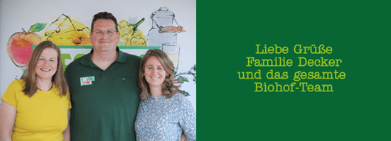 KI generiert: Das Bild zeigt drei lächelnde Personen vor einer farbenfrohen Illustration, die Früchte und landwirtschaftliche Motive darstellt. Rechts daneben befindet sich ein grüner Hintergrund mit der Aufschrift "Liebe Grüße Familie Decker und das gesamte Biohof-Team".