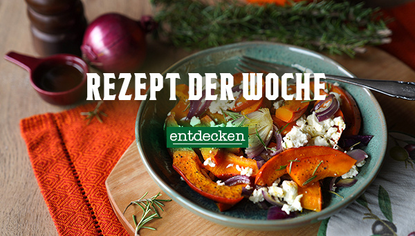 Nahaufnahme einer cremigen Suppe, garniert mit Kräutern und Pilzen, in einer Schüssel. Im Hintergrund liegen Zwiebeln. Text im Bild: „Rezept der Woche – entdecken