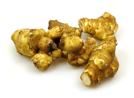 Einige frische Topinambur-Knollen auf weißem Hintergrund.