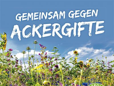  Das Bild zeigt ein Feld mit verschiedenen Blumen vor einem blauen Himmel. Am oberen Bildrand steht in weißer, grober Schrift der Slogan "GEMEINSAM GEGEN ACKERGIFTE". Die Blumen sind eine Mischung aus Wildblumen und Sonnenblumen.