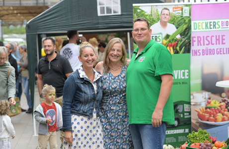 Familie Decker posieren gemeinsam vor einem Werbebanner auf dem Hoffest