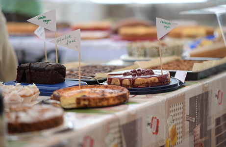 Eine Auswahl von Kuchen und Torten auf einer Veranstaltung, mit Preisschildern versehen.