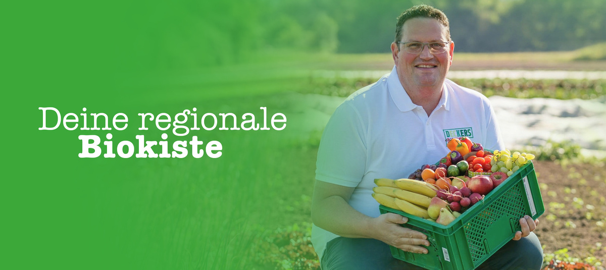 KI generiert: Das Bild zeigt einen Mann, der eine Kiste mit frischem Obst und Gemüse hält. Die Aufschrift lautet "Ihre regionale Biokiste" von "Deckers Biohof".