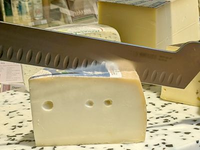 Frischer Käse in Demeter-Qualität wird sorgfältig geschnitten