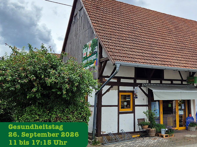 KI generiert: Altes Holzhaus mit Werbung für Gesundheitstag am 26. September 2026, 11-17:15 Uhr.