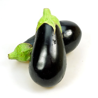 Zwei frische, dunkelviolette Auberginen mit grünen Stielen auf weißem Hintergrund.